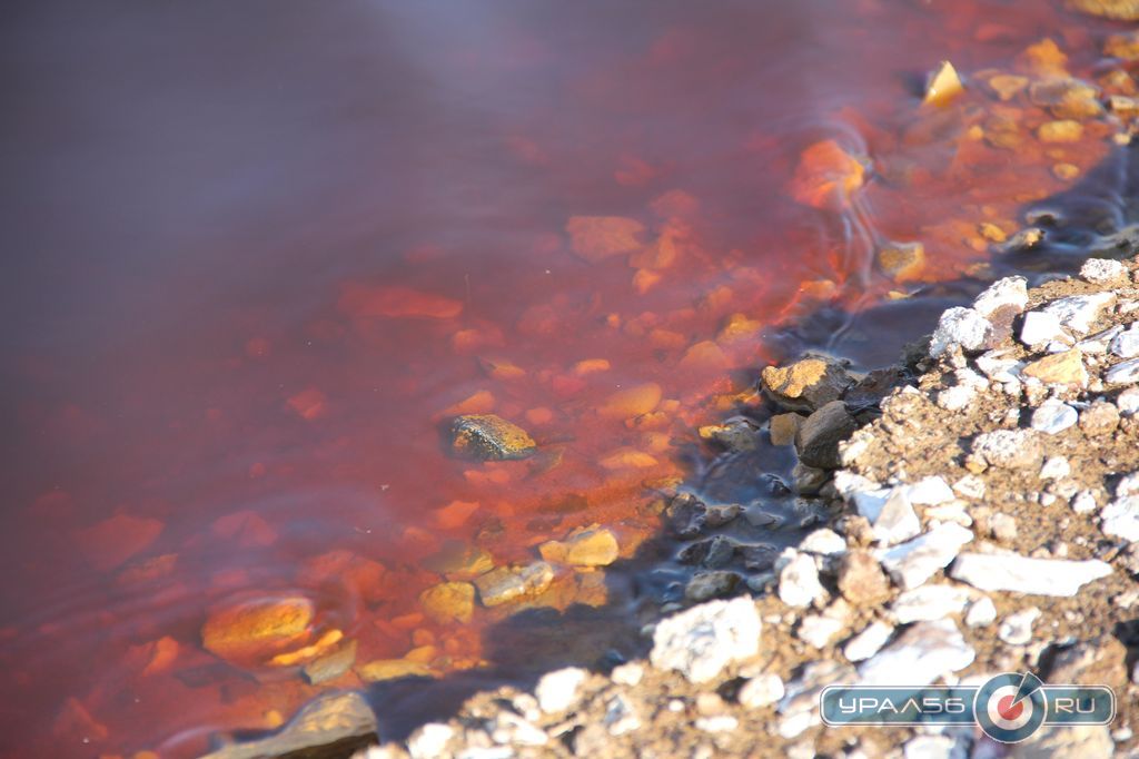 Озеро красно-бурого цвета в промзоне города Орска