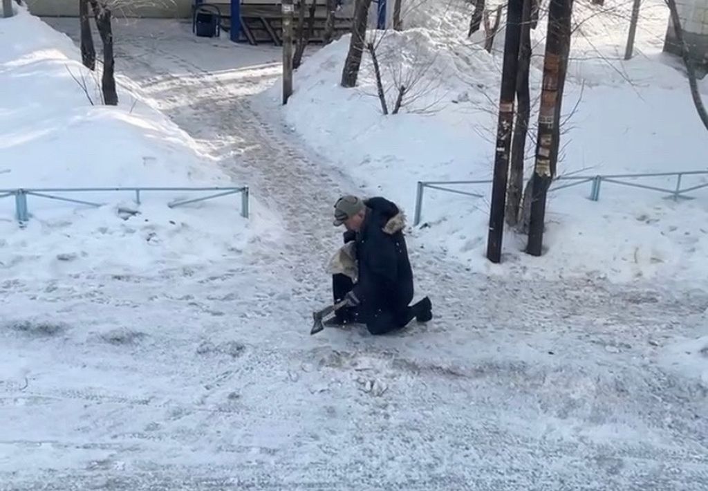 Пенсионер рубит лед на дороге. Скриншот видео