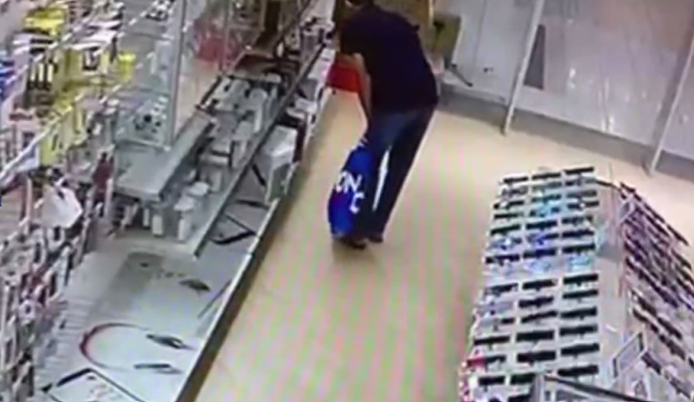 Кадр из видео в момент, когда мужчина выбирает колонки для кражи. Видео:  УМВД России по Оренбургской области