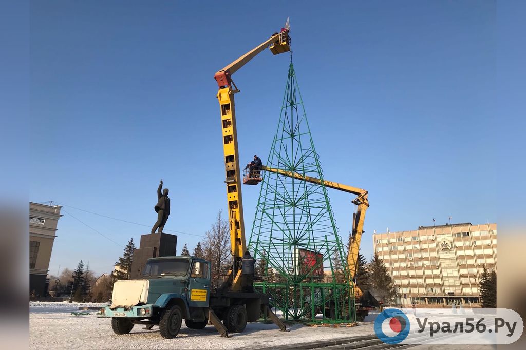 Рабочие устанавливают звезду на макушку елки