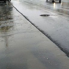 Поток воды на новой дороге в центре Орска не попадает в ливневки