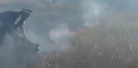 Полицейский тушит пожар. Стоп-кадр из видео УМВД по Оренбургской области 